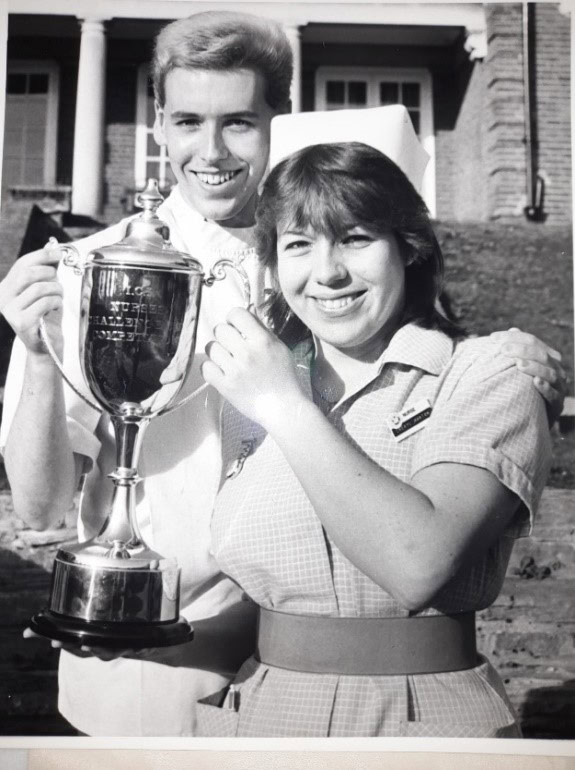 Nurses Day- Black and white image of a nurse holding a trophy.